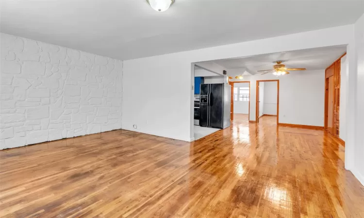 Unfurnished living room featuring ceiling fan and light wood-type flooring