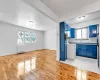 Kitchen featuring blue cabinetry, light wood-type flooring, tasteful backsplash, and sink