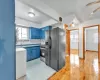 Kitchen with sink, stainless steel range with gas cooktop, black refrigerator with ice dispenser, blue cabinets, and decorative backsplash