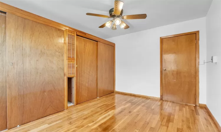 Unfurnished bedroom with ceiling fan, a closet, and wood-type flooring