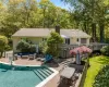 Back of property with a swimming pool side deck, a patio, and an outdoor hangout area