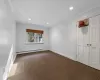 Carpeted empty room featuring a baseboard radiator and ornamental molding