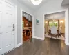 Foyer entrance with a notable chandelier, dark hardwood / wood-style floors, baseboard heating, and vaulted ceiling