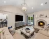 Living room with hardwood / wood-style floors, a fireplace, a chandelier, and vaulted ceiling