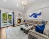 Living room featuring hardwood / wood-style flooring, lofted ceiling, a fireplace, and an inviting chandelier