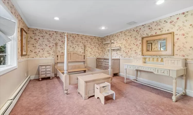 Carpeted bedroom with ornamental molding and a baseboard radiator