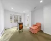 Living area featuring light carpet, baseboard heating, and ornamental molding