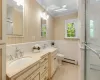 Bathroom with vanity, a baseboard heating unit, crown molding, tile patterned flooring, and toilet