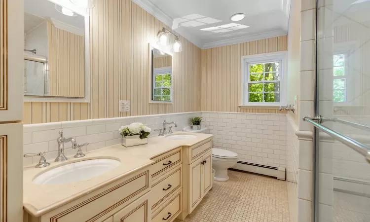 Bathroom with vanity, a baseboard heating unit, crown molding, tile patterned flooring, and toilet