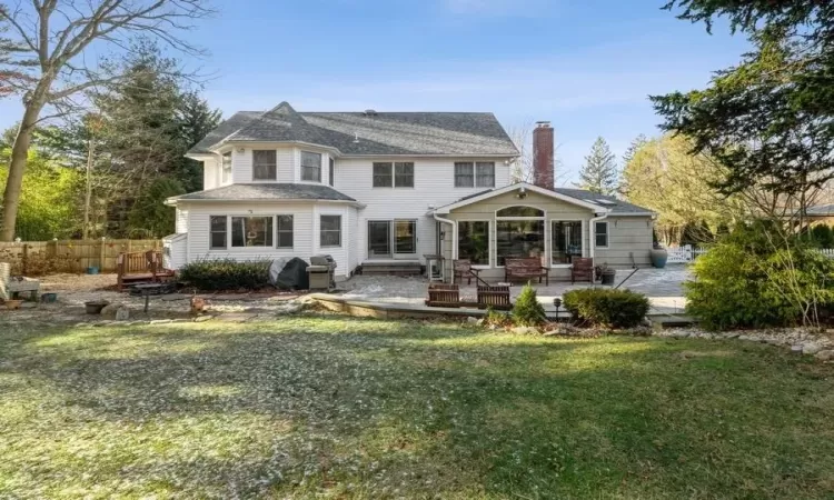 Back of house featuring a lawn and a patio