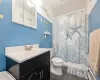 Bathroom with tile patterned flooring, vanity, toilet.