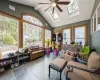 Sunroom / solarium featuring ceiling fan and vaulted ceiling with skylight