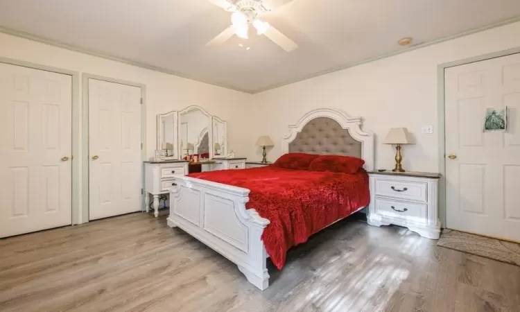 Bedroom featuring light wood-type flooring, ceiling fan, and crown molding