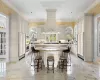 Kitchen featuring sink, stainless steel double oven, a kitchen breakfast bar, crown molding, and a kitchen island