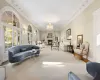 Living room featuring carpet, a notable chandelier, crown molding, and french doors