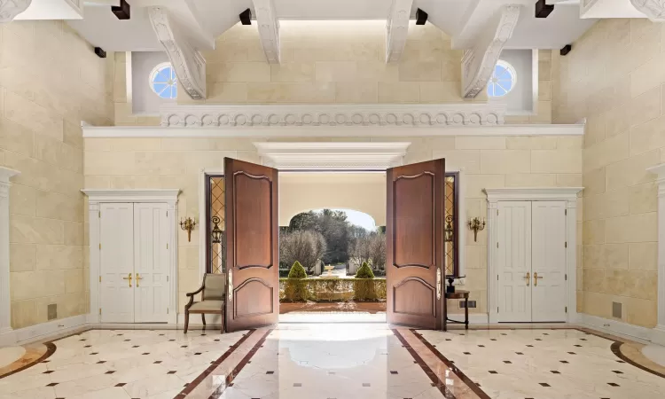 Foyer featuring beamed ceiling and a high ceiling