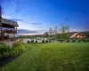 Yard at dusk featuring a patio area and a deck with water view