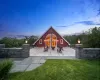 Back house at dusk with a yard, a fire pit, and a wooden deck