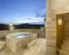 Pool at dusk featuring an in ground hot tub and a mountain view