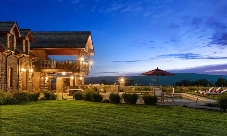 Yard at dusk featuring a mountain view and a balcony