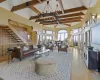 Living room with beam ceiling, high vaulted ceiling, light wood-type flooring, and an inviting chandelier