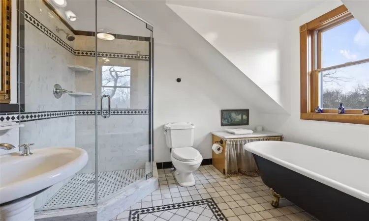 Full bathroom with tile patterned flooring, toilet, sink, and independent shower and bath