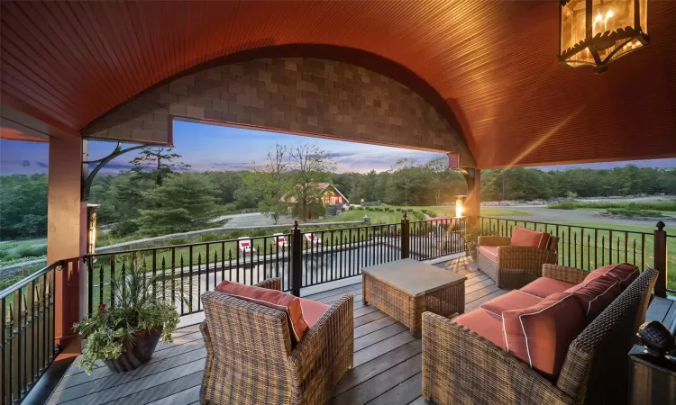 Deck at dusk with outdoor lounge area and a water view