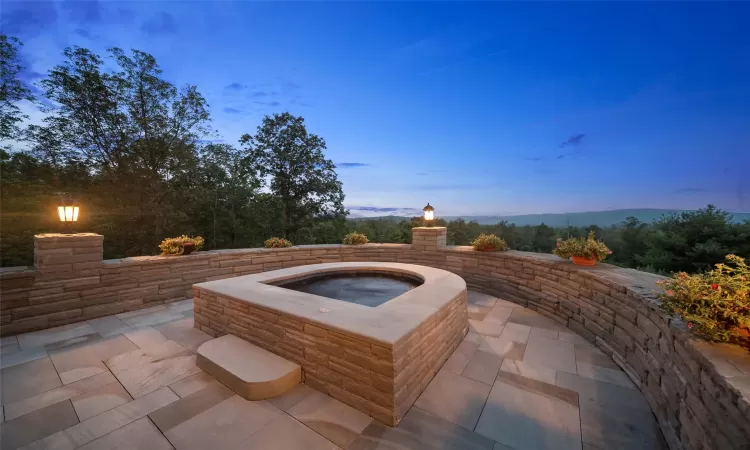 Patio terrace at dusk with an in ground hot tub