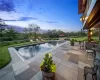 Pool at dusk featuring a patio