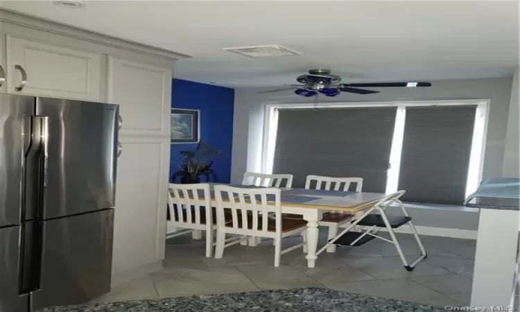 Dining space featuring ceiling fan and light tile patterned flooring