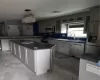 Kitchen with sink, hanging light fixtures, dark stone countertops, a kitchen island, and stainless steel appliances