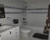 master Full bathroom with tile patterned floors, vanity, shower / bath combo, and toilet