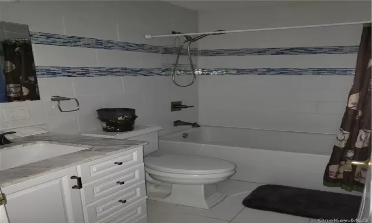 master Full bathroom with tile patterned floors, vanity, shower / bath combo, and toilet