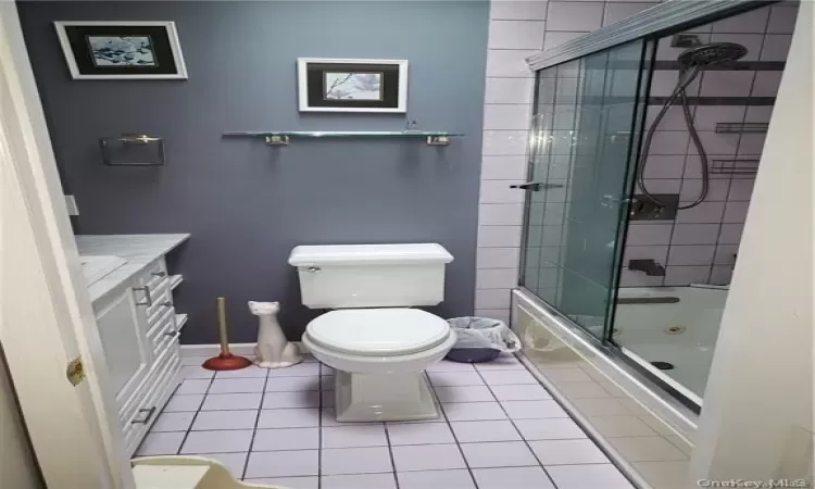 2nd floor hall Full bathroom featuring tile patterned floors, toilet, vanity, and combined bath / shower with glass door