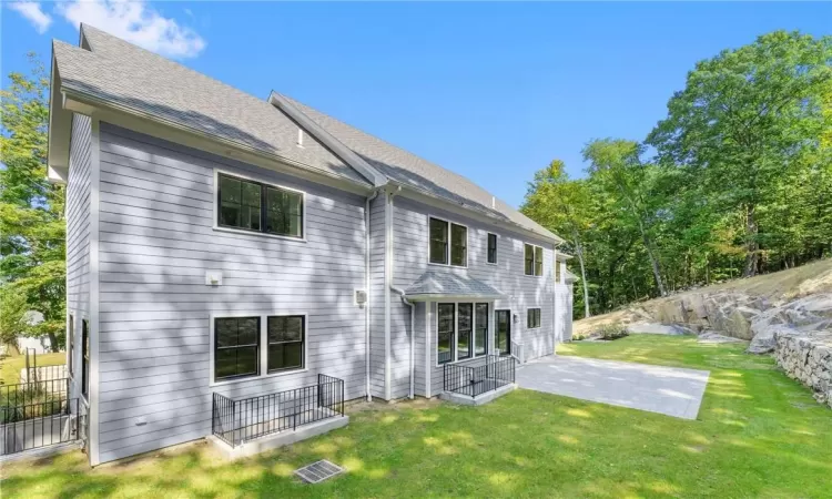 Back of property featuring a patio and a lawn