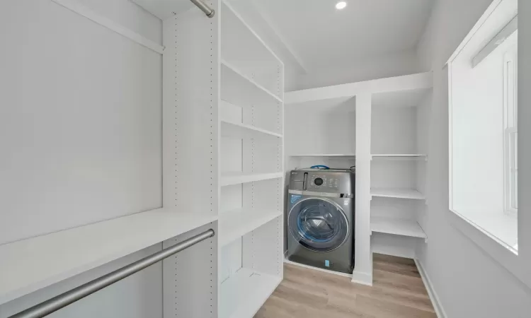 Laundry area with light wood-type flooring and washer / clothes dryer