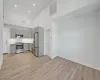 Kitchen featuring a high ceiling, light hardwood / wood-style flooring, gray cabinets, tasteful backsplash, and stainless steel appliances