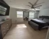 Bedroom featuring a wall mounted AC, light hardwood / wood-style flooring, ceiling fan, and ornamental molding