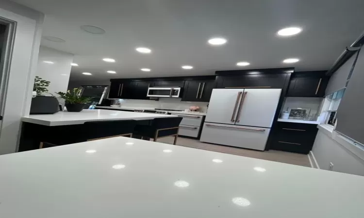 Kitchen featuring a kitchen island, white fridge, and light wood-type flooring