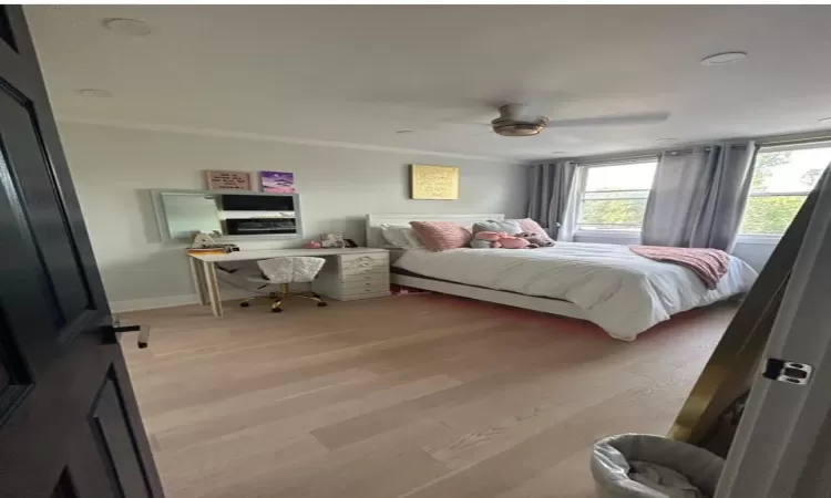 Bedroom with ceiling fan, crown molding, and light wood-type flooring