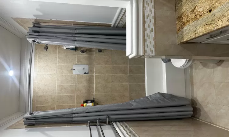 Full bathroom featuring vanity, tile patterned flooring, toilet, ornamental molding, and shower / tub combo