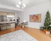 Kitchen featuring decorative light fixtures, stainless steel fridge, light hardwood / wood-style floors, and a chandelier