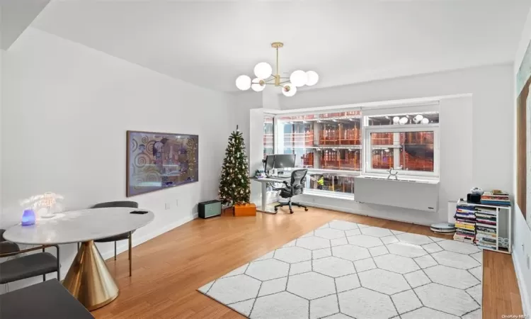 Home office featuring a notable chandelier and hardwood / wood-style flooring