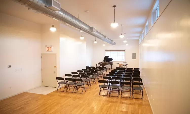 Miscellaneous room featuring a high ceiling and hardwood / wood-style flooring