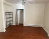 Unfurnished bedroom with ceiling fan, dark hardwood / wood-style flooring, baseboard heating, and a closet