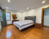 Bedroom with hardwood / wood-style floors and ornamental molding