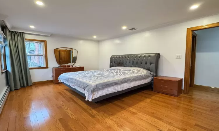 Bedroom with hardwood / wood-style floors and ornamental molding