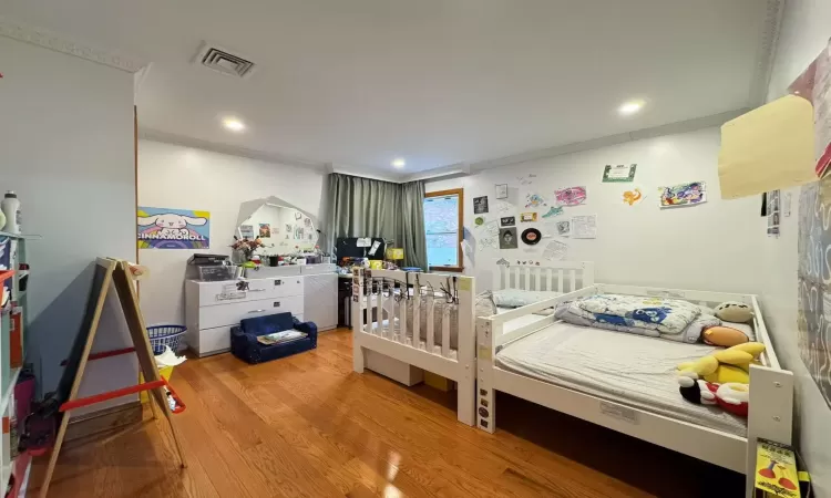 Bedroom featuring hardwood / wood-style floors and crown molding