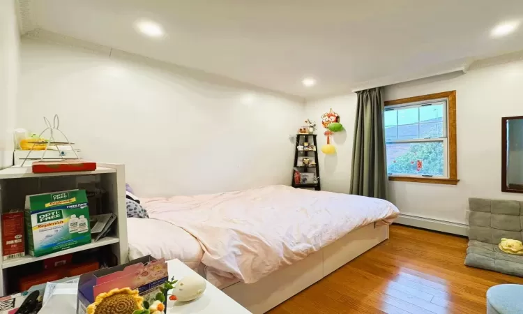 Bedroom featuring a baseboard radiator and light wood-type flooring