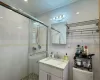 Bathroom featuring vanity, a shower with door, and tile walls